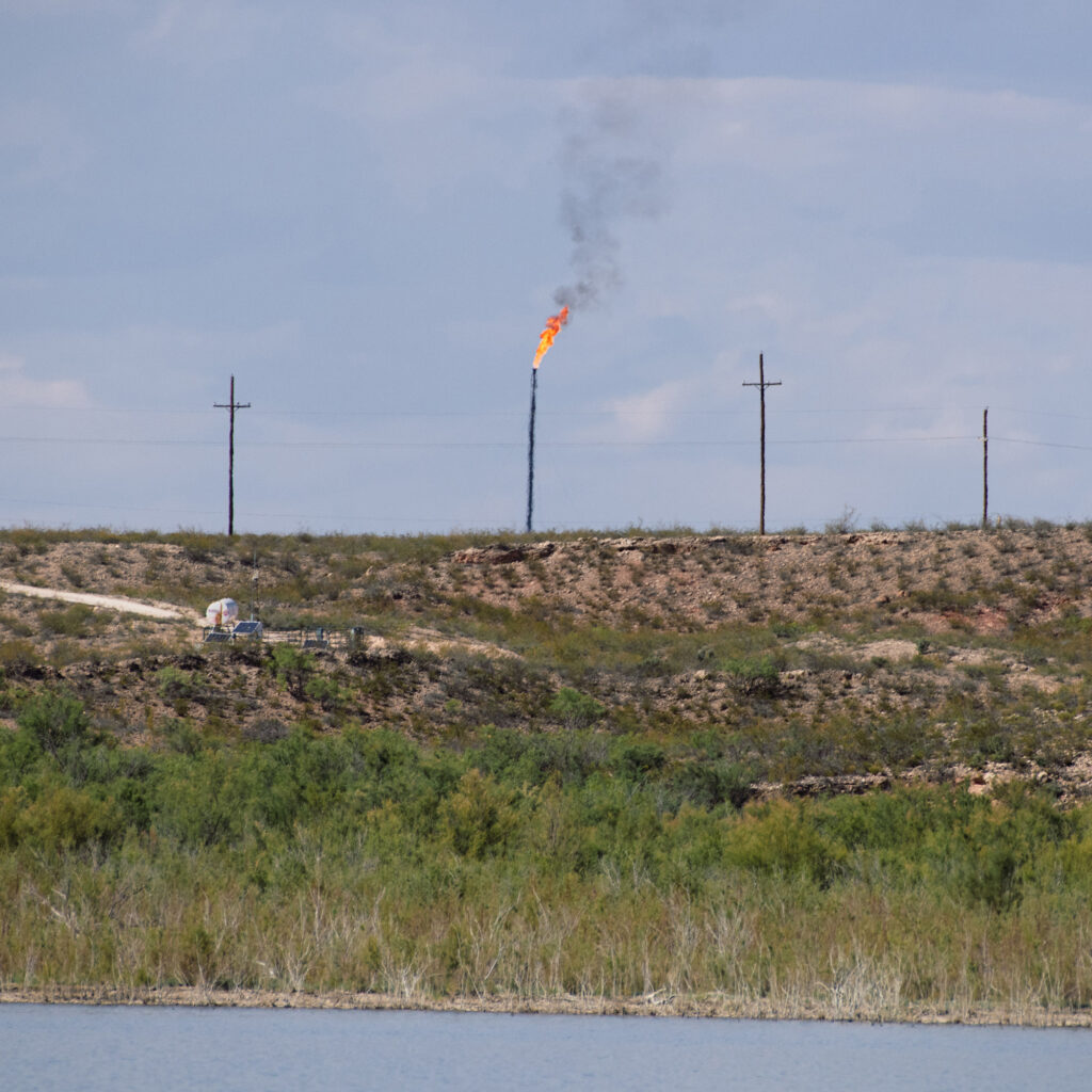 A methane gas flare burns four miles from the Red Bluff Reservoir in Reeves County, Texas on Feb. 24, 2020. NGL Water Solutions Permian has proposed to discharge treated produced water into the reservoir. Credit: Justin Hamel